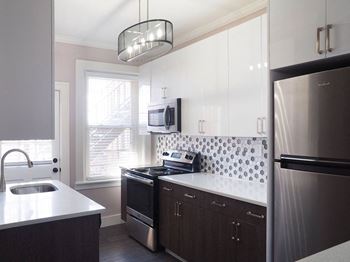 A modern kitchen with dark wood cabinets and stainless steel appliances
